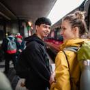 Two friends are looking excited to be boarding a train, commuting to their next destination.