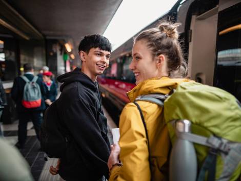 Two friends are looking excited to be boarding a train, commuting to their next destination.